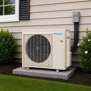 Daikin Aurora single-zone mini split heat pump condenser installed on outdoor pad beside residential home
